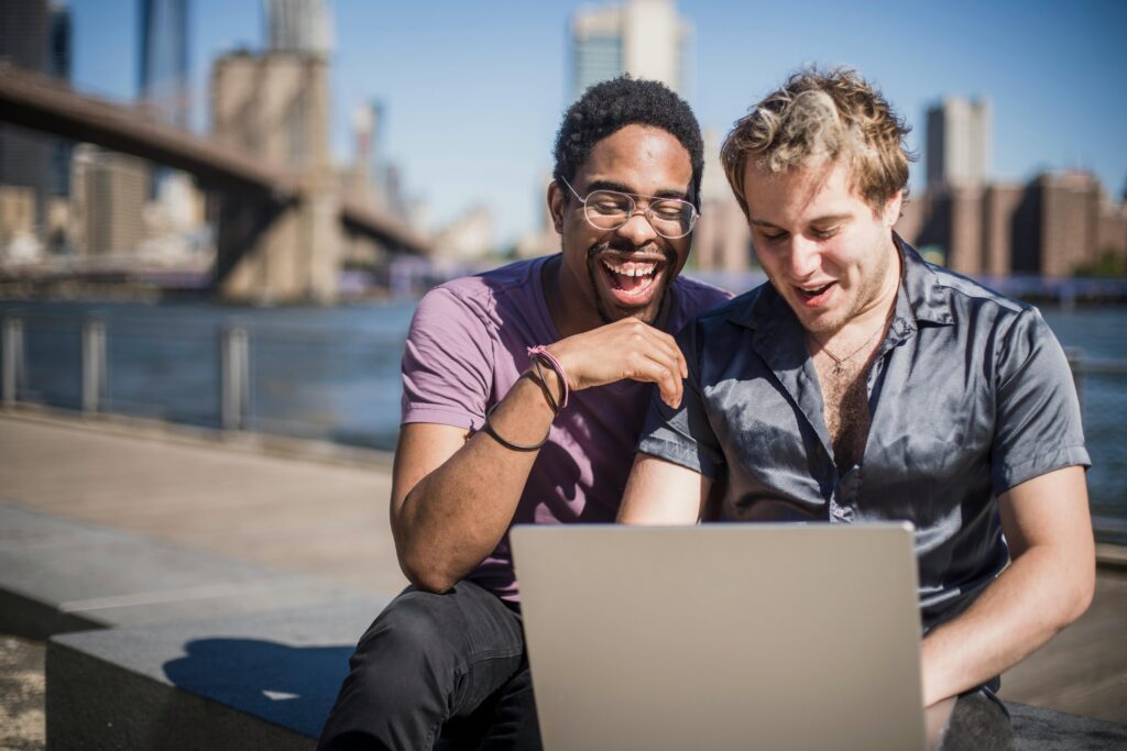 Two Men Sitting on Floor Using Macbook